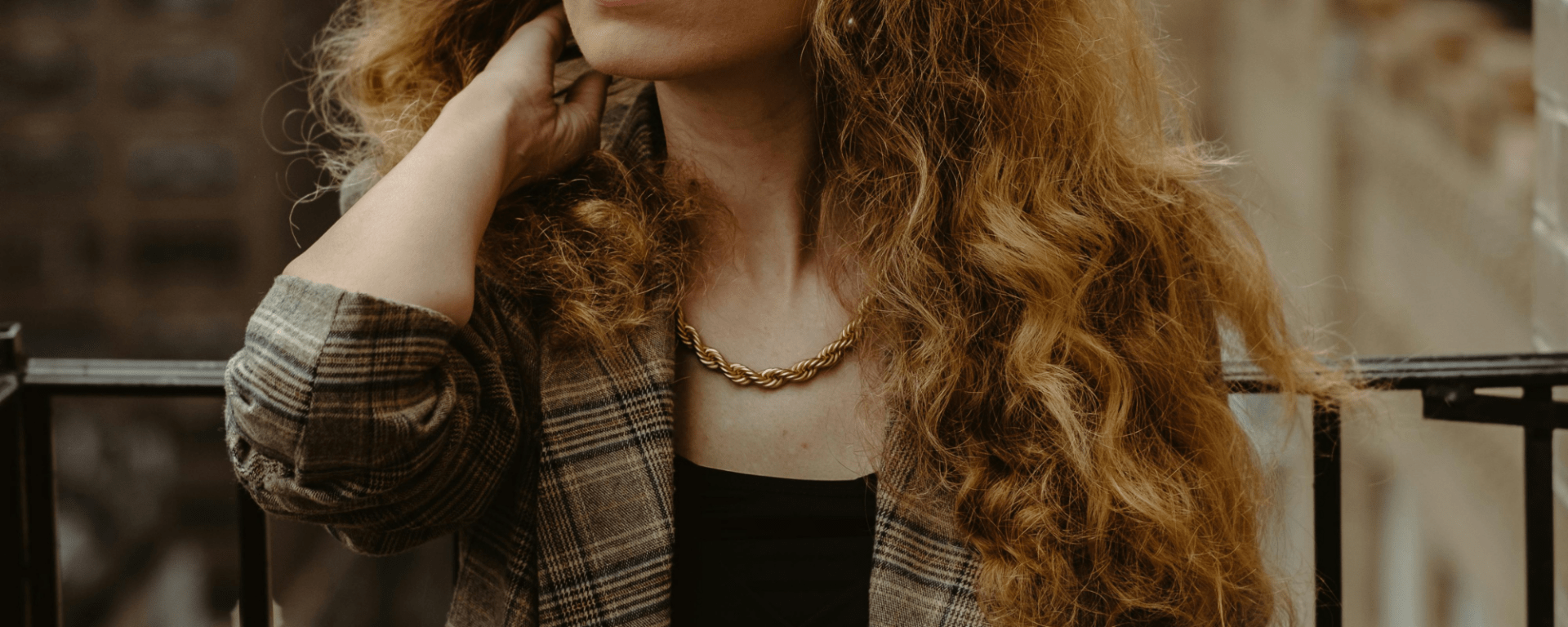 Woman wearing a gold necklacea and blazer