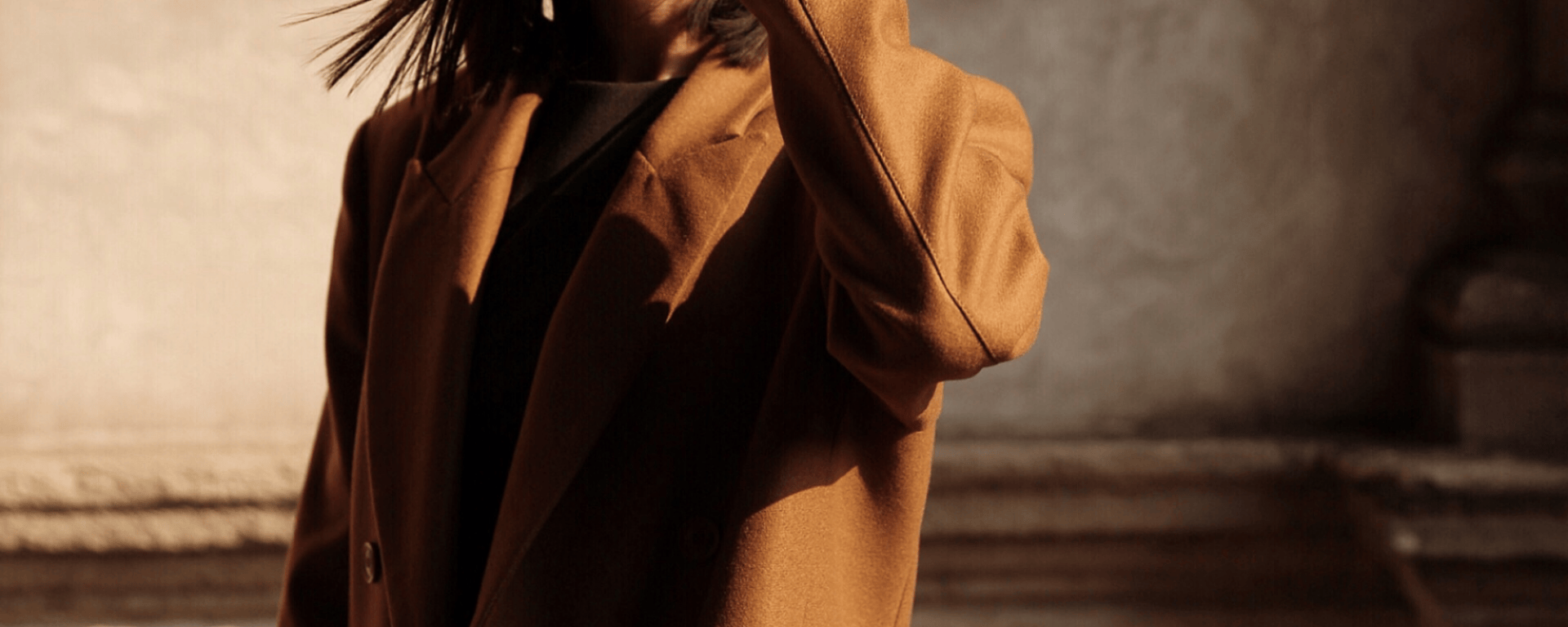 A woman wearing a camel coat